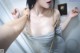 A woman in a gray dress is taking a selfie.