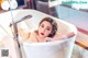A woman laying in a bathtub in a bathroom.