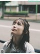 A woman with long black hair looking up at the sky.