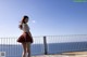 A woman in a red and black plaid skirt standing on a pier.