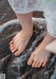 A woman's bare feet in a bowl of water.